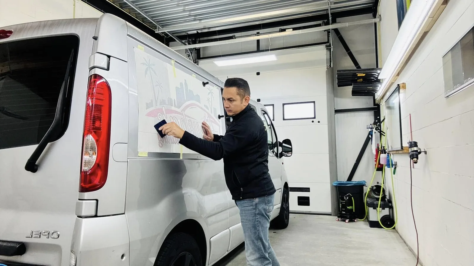 Glenn plakt belettering op een bus