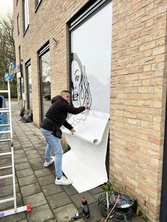Een muurprint wordt aangebracht op een gevel